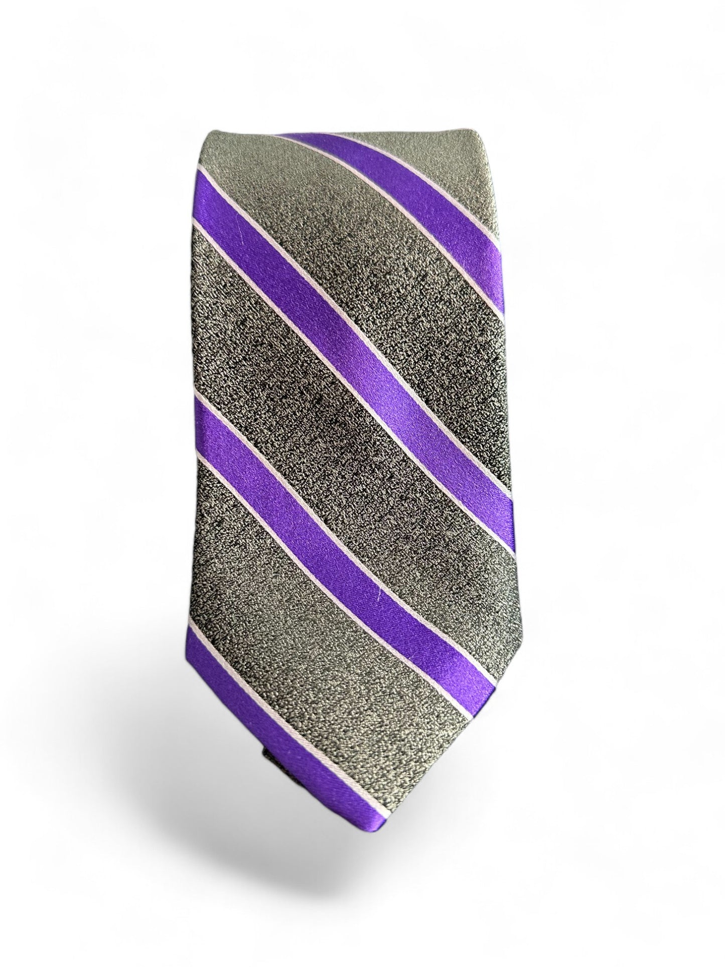 Drape yourself in luxury with the SUITCAFE Silk Woven Charcoal & Purple Striped Tie. Handmade using 100% silk, this tie features a sophisticated charcoal wide stripe and a sleek purple narrow stripe. This elegant addition to your wardrobe can be paired with many types of classic suits.