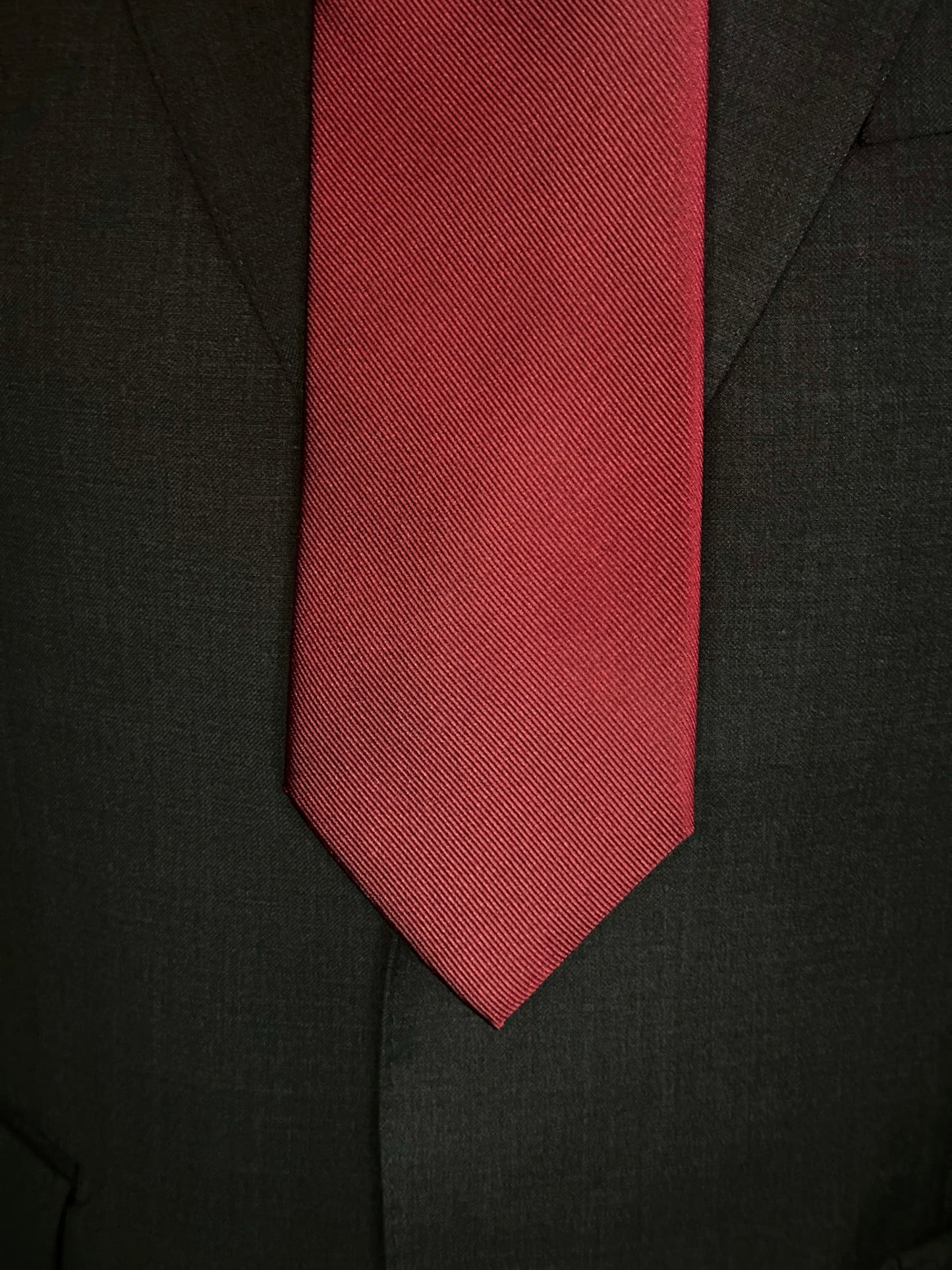Solid ties are beautifully paired with the more busy of patters of bold stripes and heavy plaids. However, there is something so understated and elegant about a solid tie with a solid suit. Whether that be navy, charcoal or black a burgundy tie fits well with a white shirt and even a navy blazer with jeans.
