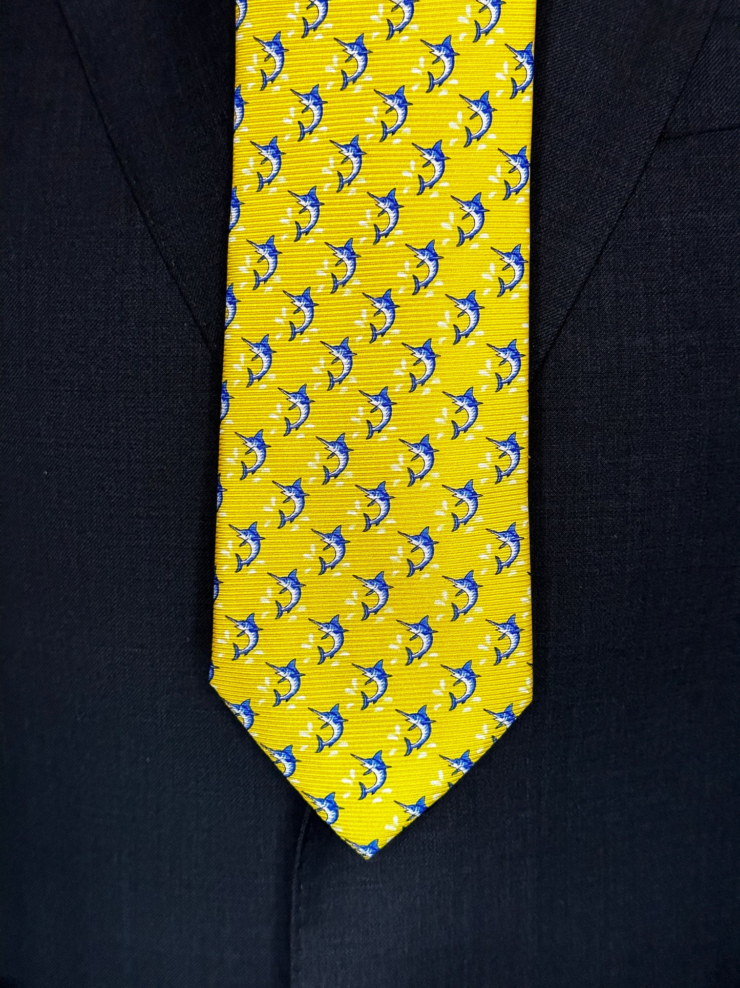 This beautiful 100% silk twill necktie features the swordfish motif with small splashes of water. Being a geometric type pattern, this tie is most interesting because people tend to look twice to realize that the pattern is made up of blue swordfish. Hermes style..