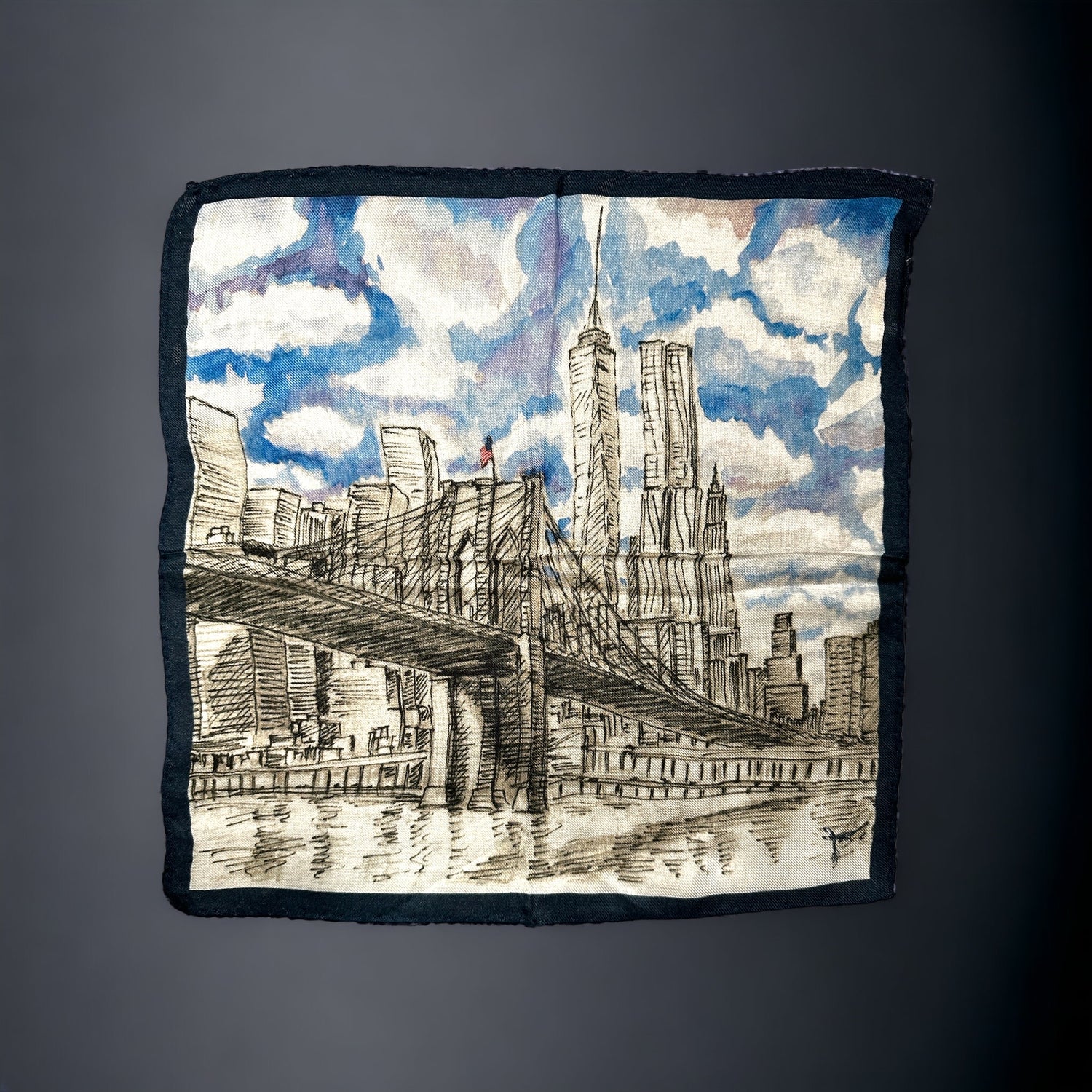 A silk pocket square of the New York City skyline as seen from the Brooklyn Bridge. Nothing more iconic than NYC and here it is shown in a beautiful watercolor and pencil artwork on a silk pocket square complete with a party cloudy sky. Hand rolled edges. 
