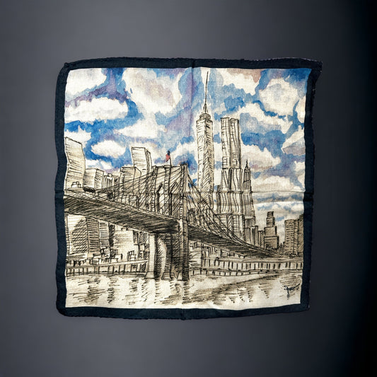 A silk pocket square of the New York City skyline as seen from the Brooklyn Bridge. Nothing more iconic than NYC and here it is shown in a beautiful watercolor and pencil artwork on a silk pocket square complete with a party cloudy sky. Hand rolled edges. 