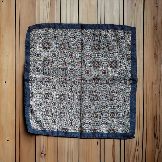 Hand rolled edges on this silk pocket square create gorgeous points that keep their position when using the breast pocket on a jacket. The brown and ice blue circular pattern is a stunning classic all around geometric design. On the reverse is a different fun pattern of different colorful florets on navy. A fun and playful pocket square for every occasion.