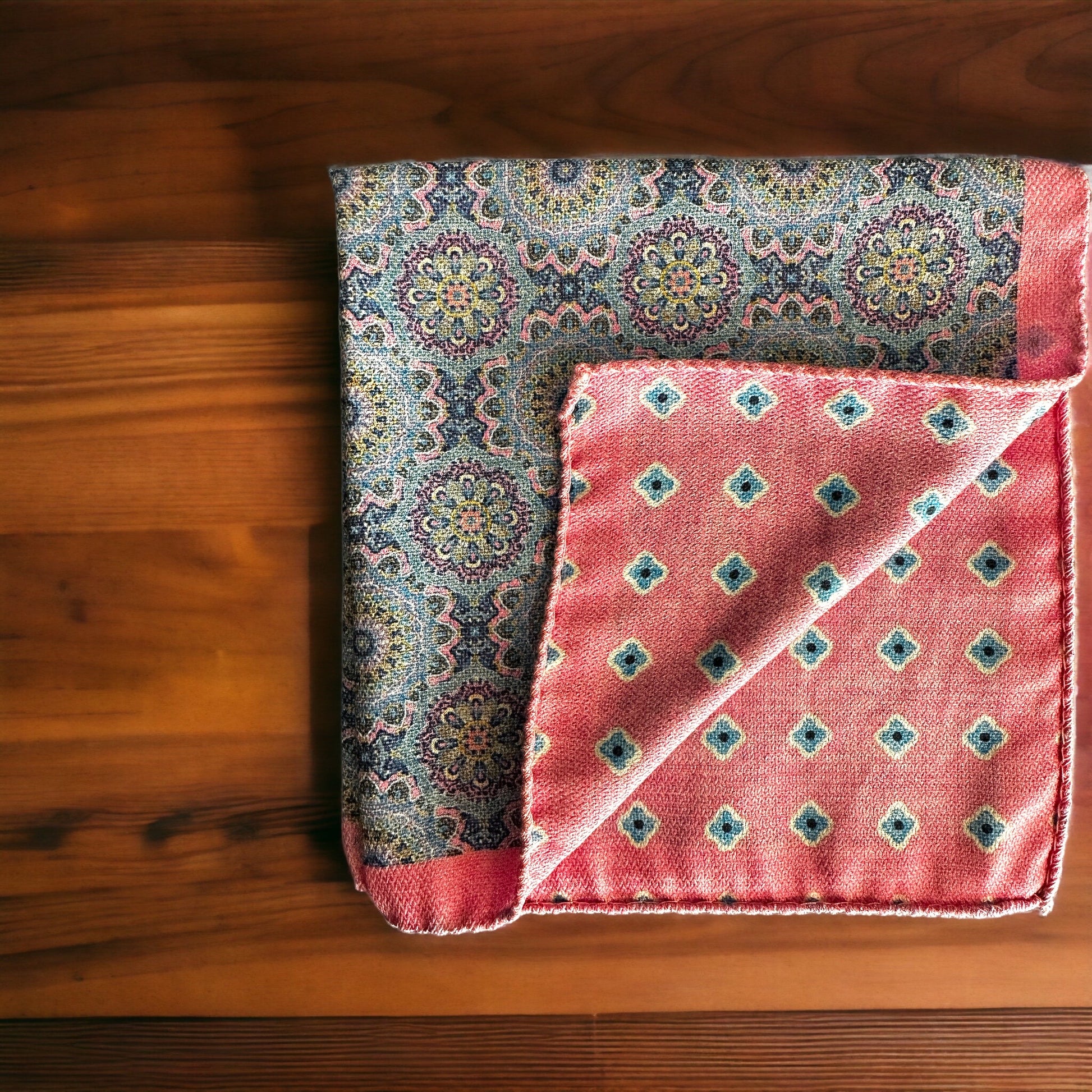 Hand rolled edges on this silk pocket square create gorgeous points that keep their position when using the breast pocket on a jacket. The pale pink and light blue circular pattern is a stunning classic all around geometric design. On the reverse is a different fun pattern of different colorful florets of blue on pink. A fun and playful pocket square for every occasion.