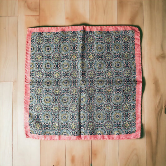 Hand rolled edges on this silk pocket square create gorgeous points that keep their position when using the breast pocket on a jacket. The pale pink and light blue circular pattern is a stunning classic all around geometric design. On the reverse is a different fun pattern of different colorful florets of blue on pink. A fun and playful pocket square for every occasion.