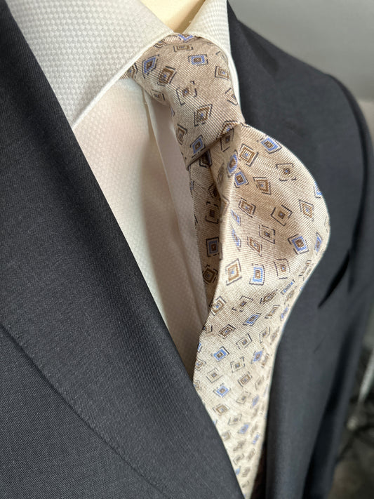 A 100% silk tie in pastel beige that has the characteristics and feel of linen. For those light weight summer outfits and thin cotton summer dress shirts, including Swiss voile, you need a tie that carries the same type of personality. The weave of this silk looks like the weave of pure linen, but has the smooth feel of silk.