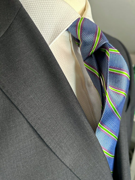 A general all around great tie to wear with any suit, shirt for any occasion. With two different types of silk in the same necktie, the stripe being satin and the broad section being woven, this tie makes an all day knot that does not have to be readjusted. With colorations of kelly green and purple stripes, you cannot make a mistake creating a look with this tie pairing with any suit in your closet.