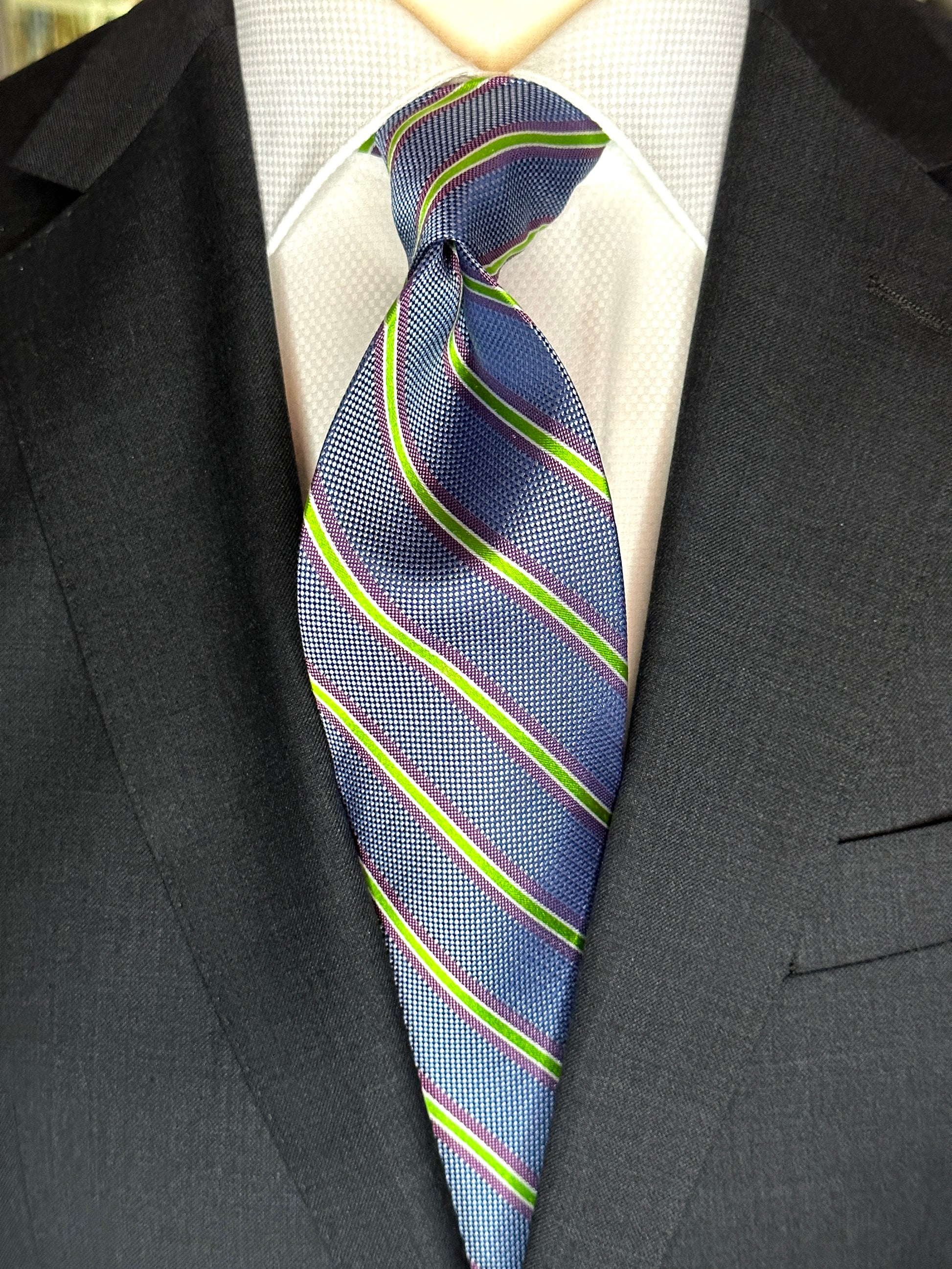 A general all around great tie to wear with any suit, shirt for any occasion. With two different types of silk in the same necktie, the stripe being satin and the broad section being woven, this tie makes an all day knot that does not have to be readjusted. With colorations of kelly green and purple stripes, you cannot make a mistake creating a look with this tie pairing with any suit in your closet.