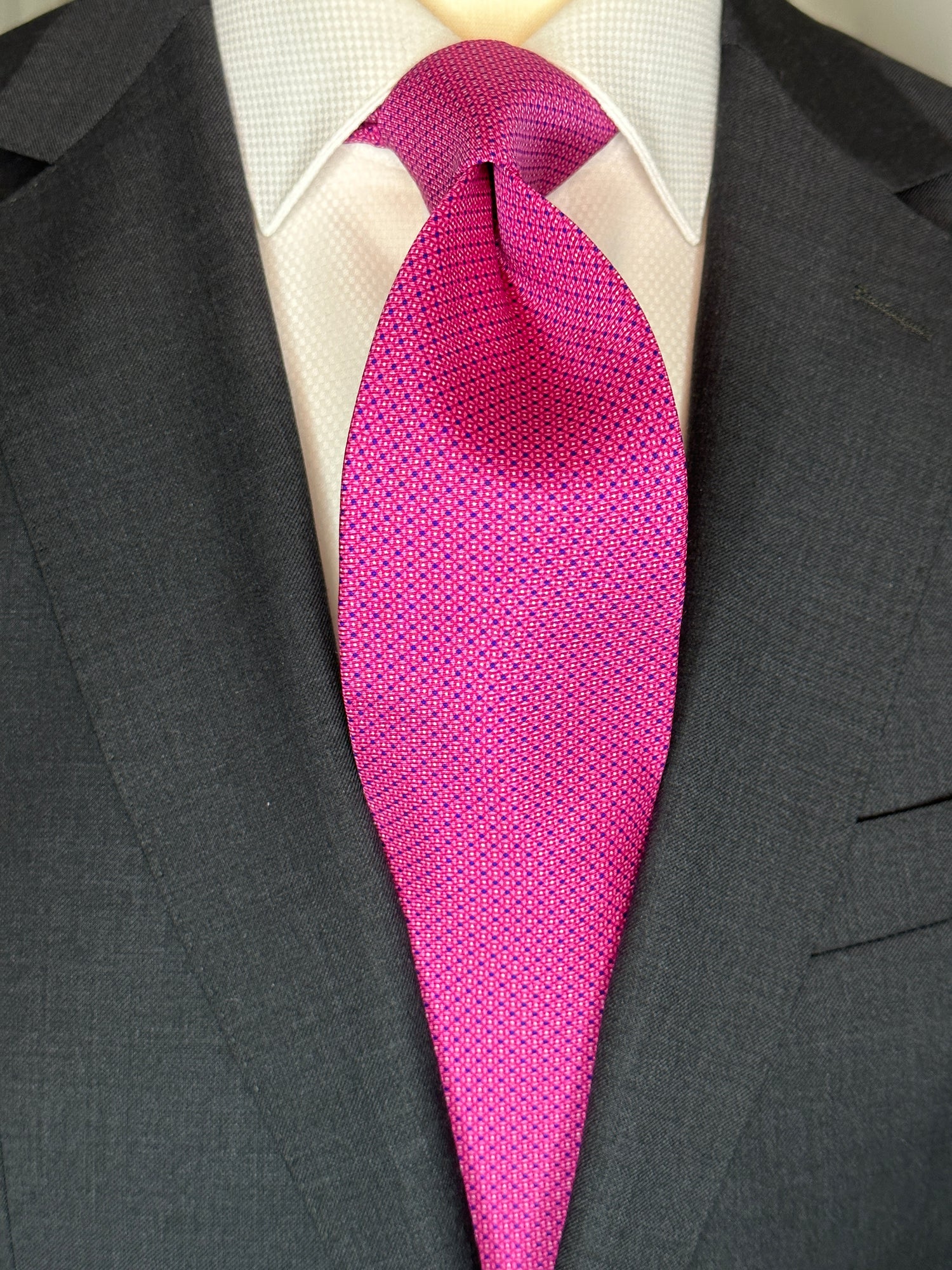 100% silk twill is a luxurious and rich silk. Smooth to the touch with a lightweight soft feel, this tie makes a striking statement in bright pink. It does, however, become toned down due to its very neat and small mini dot geometric pattern. Great for everyday business or law this tie goes out day and night.