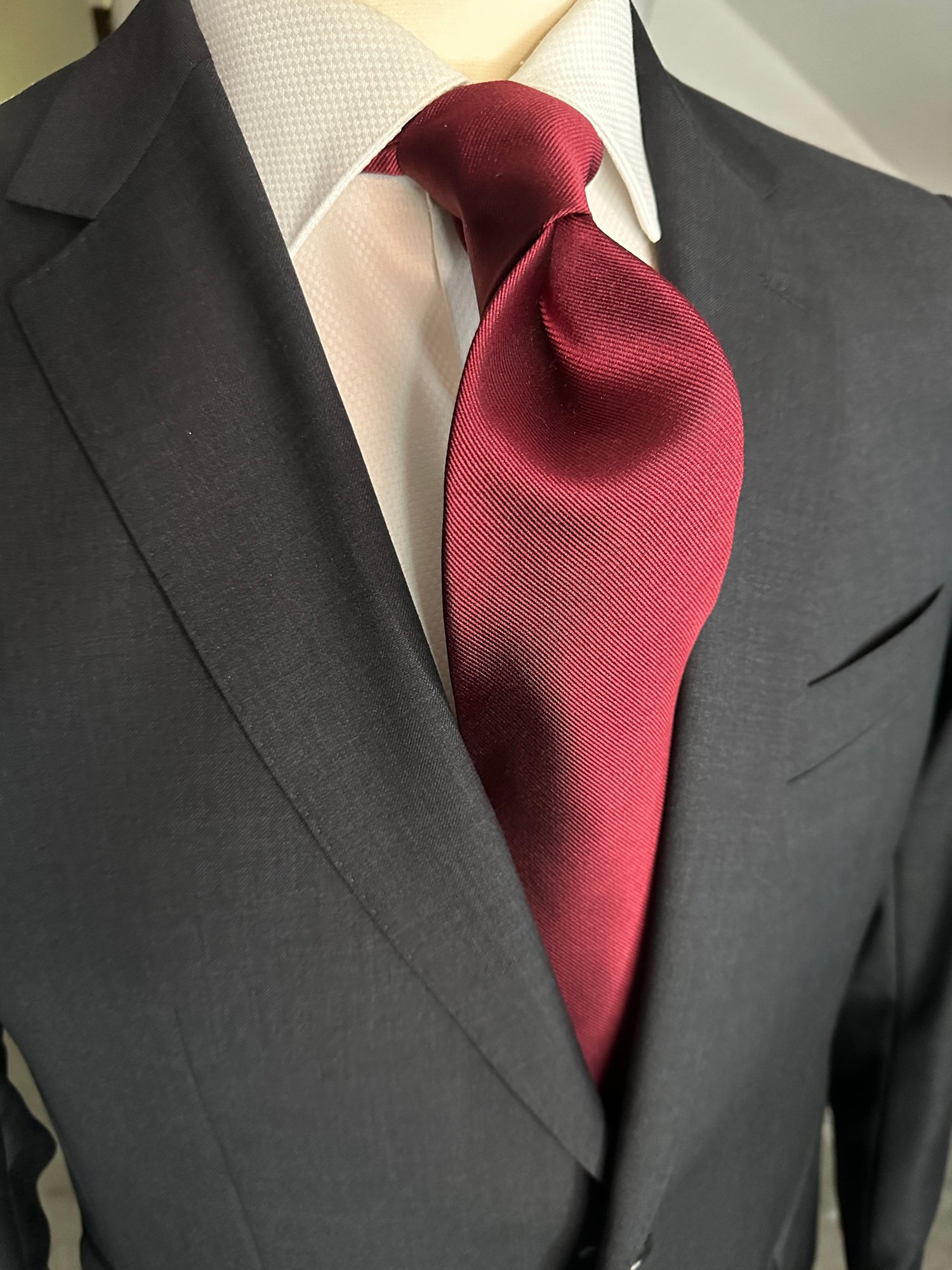 Solid ties are beautifully paired with the more busy of patters of bold stripes and heavy plaids. However, there is something so understated and elegant about a solid tie with a solid suit. Whether that be navy, charcoal or black a burgundy tie fits well with a white shirt and even a navy blazer with jeans.