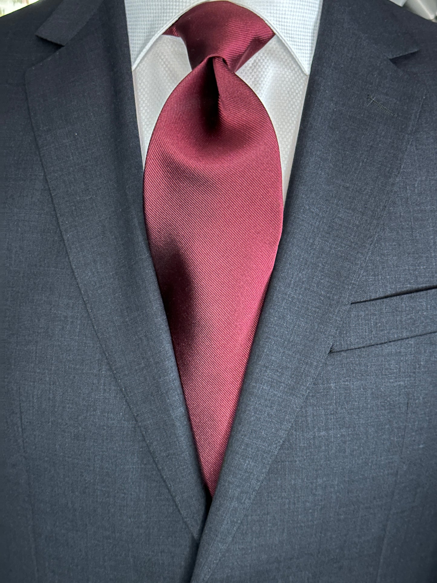 Solid ties are beautifully paired with the more busy of patters of bold stripes and heavy plaids. However, there is something so understated and elegant about a solid tie with a solid suit. Whether that be navy, charcoal or black a burgundy tie fits well with a white shirt and even a navy blazer with jeans.
