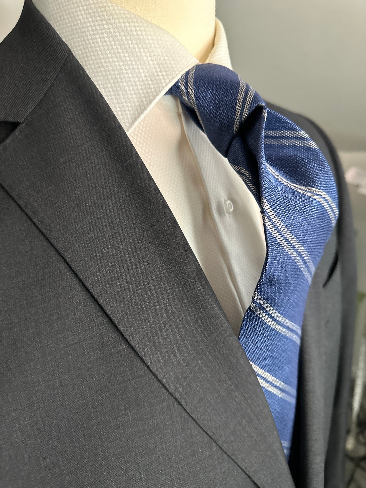 The textured woven silk of this blue denim tie is perfect for all seasons. The texture goes well with wool flannels, plaids and interesting mini checks. Made from 100% silk, the denim blue necktie combines well with pure white for that contrast or a pale grey to bring out the double charcoal stripe in the tie.