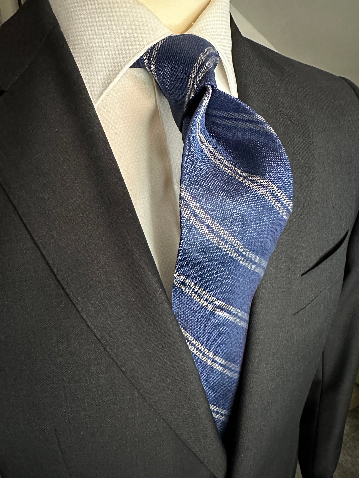 The textured woven silk of this blue denim tie is perfect for all seasons. The texture goes well with wool flannels, plaids and interesting mini checks. Made from 100% silk, the denim blue necktie combines well with pure white for that contrast or a pale grey to bring out the double charcoal stripe in the tie.