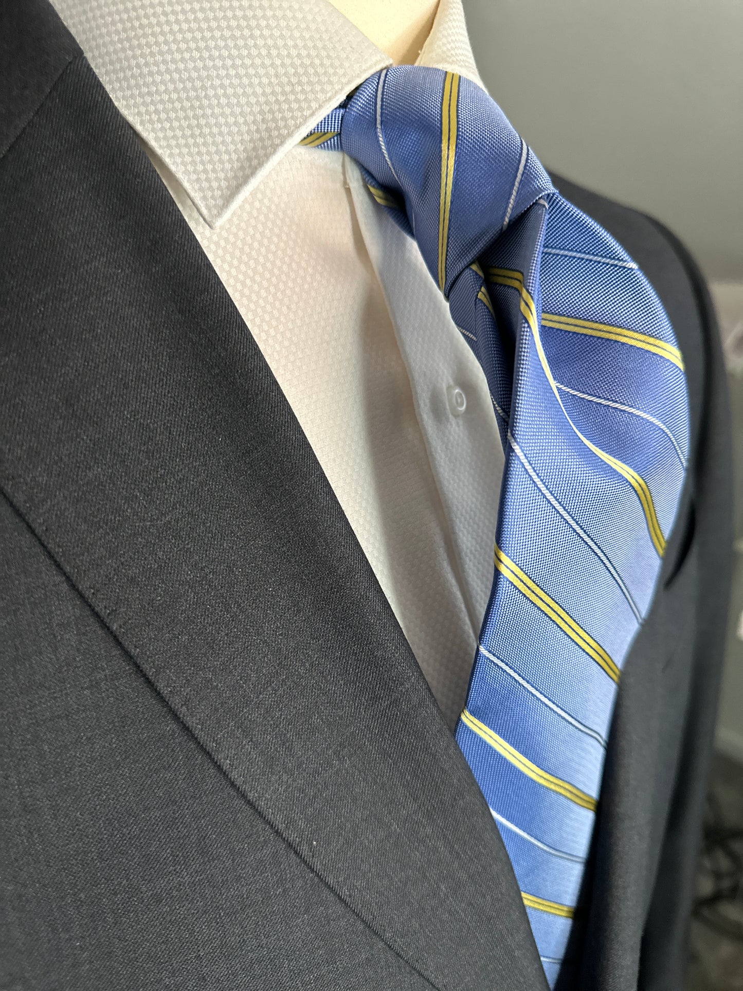 This pale blue woven silk necktie has two different types of silk. The yellow stripes are satin silk with the broad stripes in 100% woven silk. Easily used on a sky blue or white shirt with a multiple array of different suit colors, this tie fits well for daytime and evening time use.