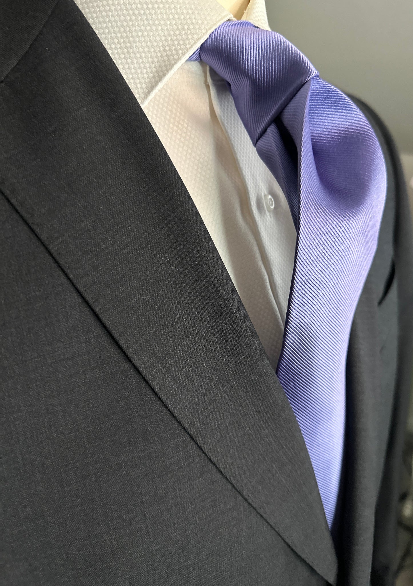Solid ties are beautifully paired with the more busy of patters of bold stripes and heavy plaids. However, there is something so understated and elegant about a solid tie with a solid suit. Whether that be navy, charcoal or black a lavender tie fits well with a white shirt and even a navy blazer with jeans.