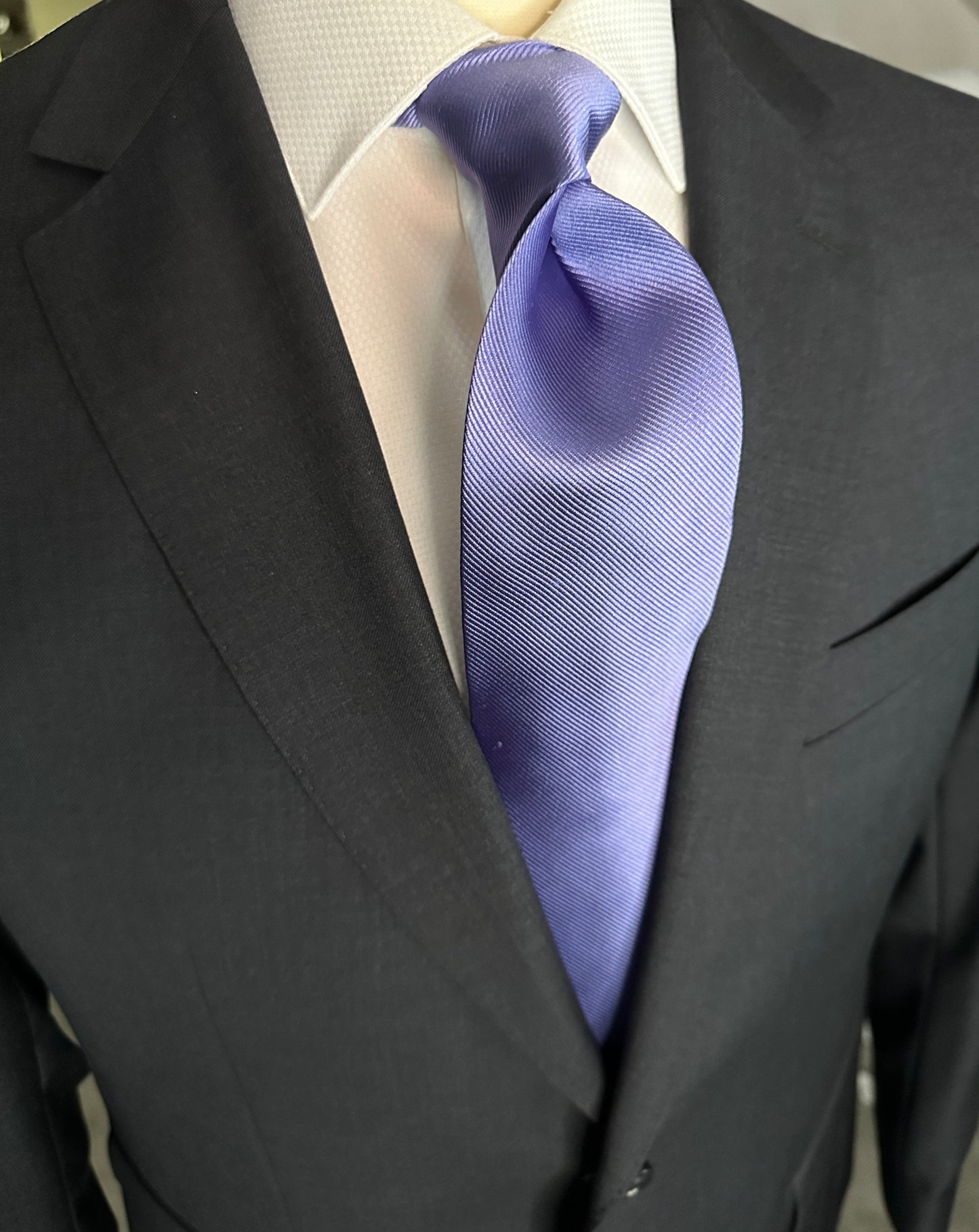Solid ties are beautifully paired with the more busy of patters of bold stripes and heavy plaids. However, there is something so understated and elegant about a solid tie with a solid suit. Whether that be navy, charcoal or black a lavender tie fits well with a white shirt and even a navy blazer with jeans.