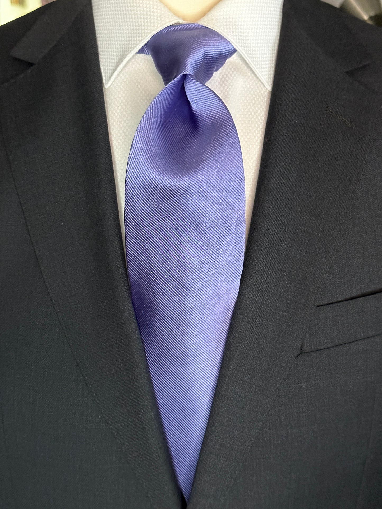 Solid ties are beautifully paired with the more busy of patters of bold stripes and heavy plaids. However, there is something so understated and elegant about a solid tie with a solid suit. Whether that be navy, charcoal or black a lavender tie fits well with a white shirt and even a navy blazer with jeans.