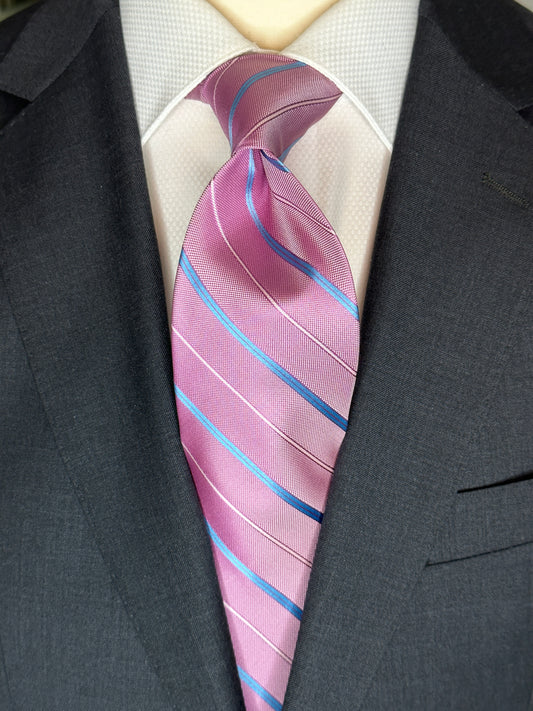 This pale pink woven silk necktie has two different types of silk. The blue stripes are satin silk with the broad stripes in 100% woven silk. Easily used on a sky blue shirt with a multiple array of different suit colors, this tie fits well for daytime and evening time use.