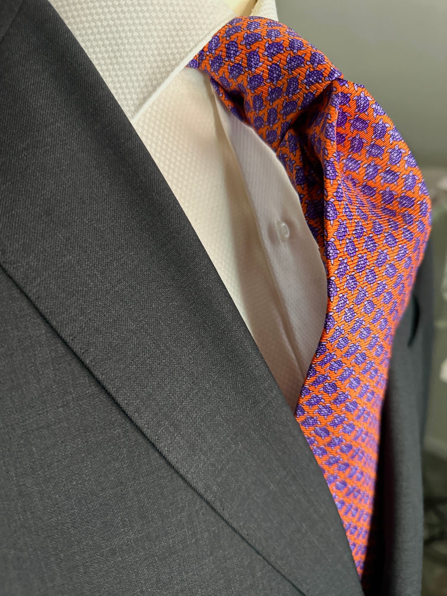 A tie with turtles, what could be better? You don't see turtles? This beautiful geometric pattern is made of closely bunched turtles in purple against an orange background. What is so great about this tie is that from afar this necktie is a neat pattern, but as you get closer it can be seen there are small turtles together. Hermes style. 