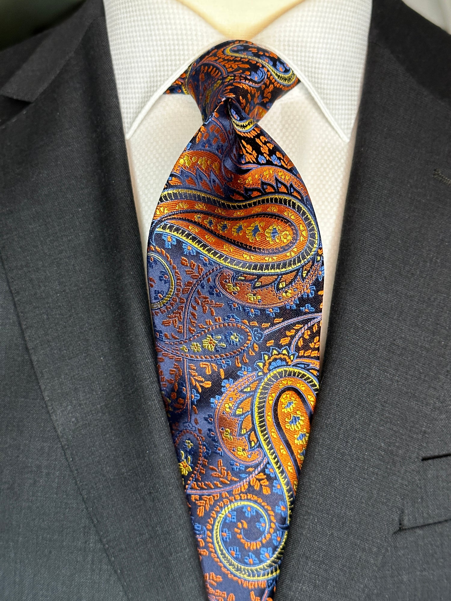 This large paisley orange and blue 100% silk woven tie is stunningly gorgeous and a very rare type to find. It brightens up any dark suit and adds sophistication and elegance to any combination. Best with solid color shirt such as white and baby blue, Be a bit more exotic and wear this tie with a dark navy shirt. 