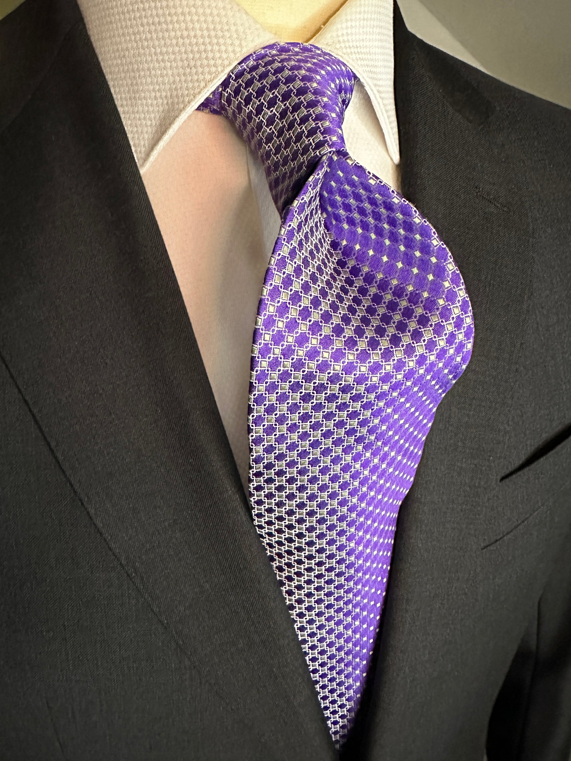 This 100% silk necktie is made from the finest Italian woven silk. The pattern is a small neat geometric making for a cool, crisp look. Inside each small checkered square is a small pale green square. This is a very sophisticated tie for business, dinners or even a wedding.