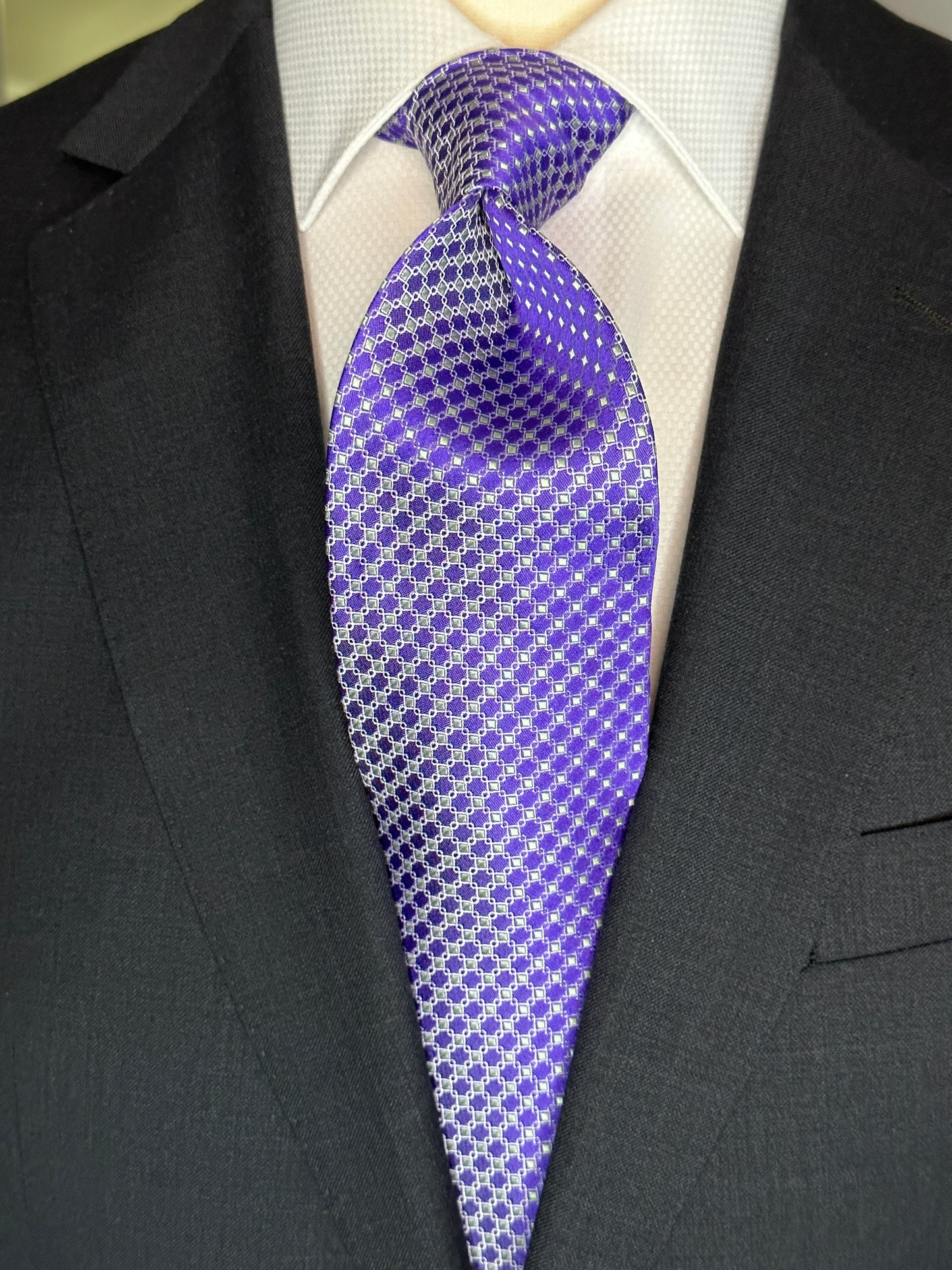 This 100% silk necktie is made from the finest Italian woven silk. The pattern is a small neat geometric making for a cool, crisp look. Inside each small checkered square is a small pale green square. This is a very sophisticated tie for business, dinners or even a wedding.