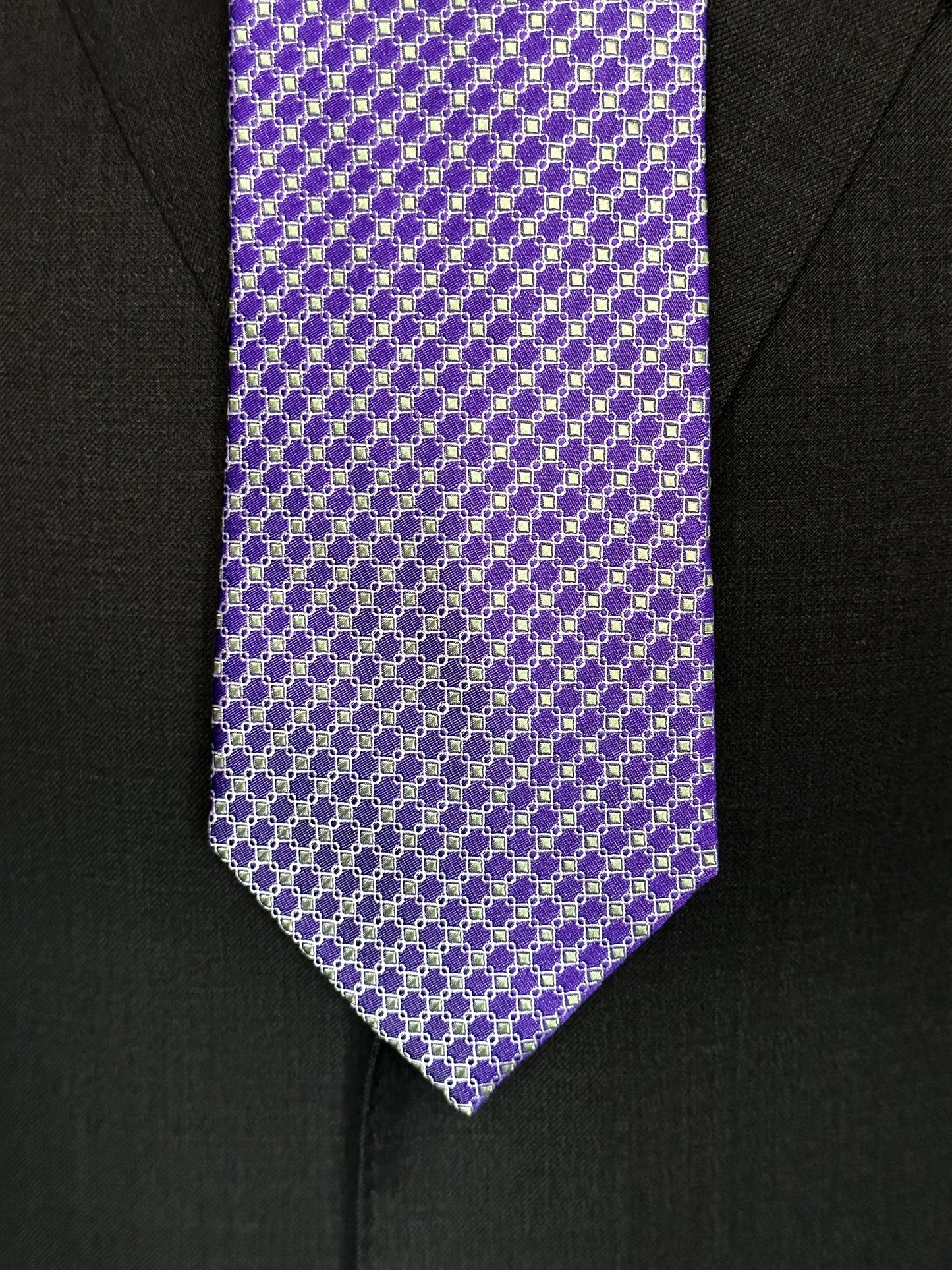 This 100% silk necktie is made from the finest Italian woven silk. The pattern is a small neat geometric making for a cool, crisp look. Inside each small checkered square is a small pale green square. This is a very sophisticated tie for business, dinners or even a wedding.