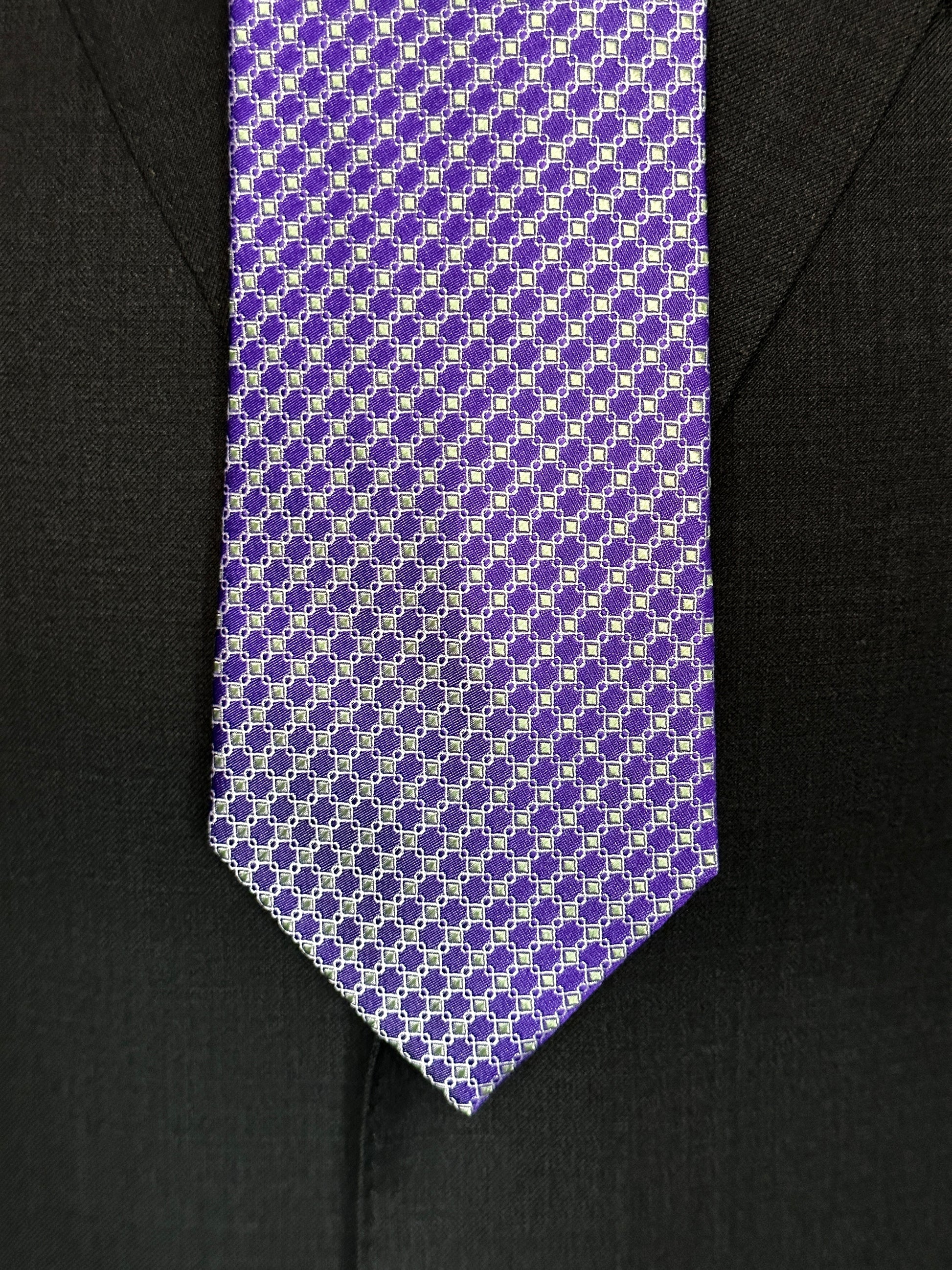 This 100% silk necktie is made from the finest Italian woven silk. The pattern is a small neat geometric making for a cool, crisp look. Inside each small checkered square is a small pale green square. This is a very sophisticated tie for business, dinners or even a wedding.