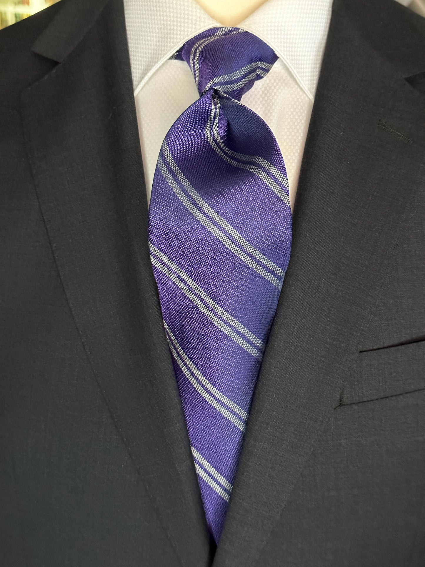 The textured woven silk of this purple silk tie is perfect for all seasons. The texture goes well with wool flannels, plaids and interesting mini checks. Made from 100% silk, the purple texture necktie combines well with pure white for that contrast or a pale grey to bring out the double charcoal stripe in the tie. 