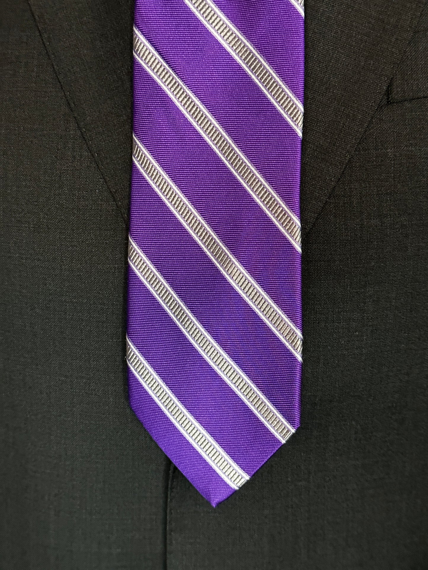 This beautiful deep purple woven silk tie with stone grey stripe pairs perfectly with a soft charcoal grey suit or navy pinstripe. For summer it would also go well with the classic tan summer suit. Try it with a navy blazer and pale grey trousers for a mid afternoon summer look.