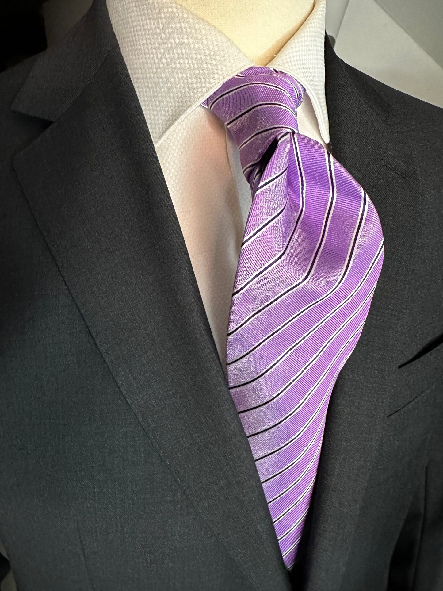 This lavender silk tie is extremely soft in color. The navy and narrow white pinstripes give it that extra definition. Woven silk creates a sturdy slightly thicker knot that stays all day. This color is great with a crisp white shirt, sky blue or pale lavender solid, stripes or plaid.  