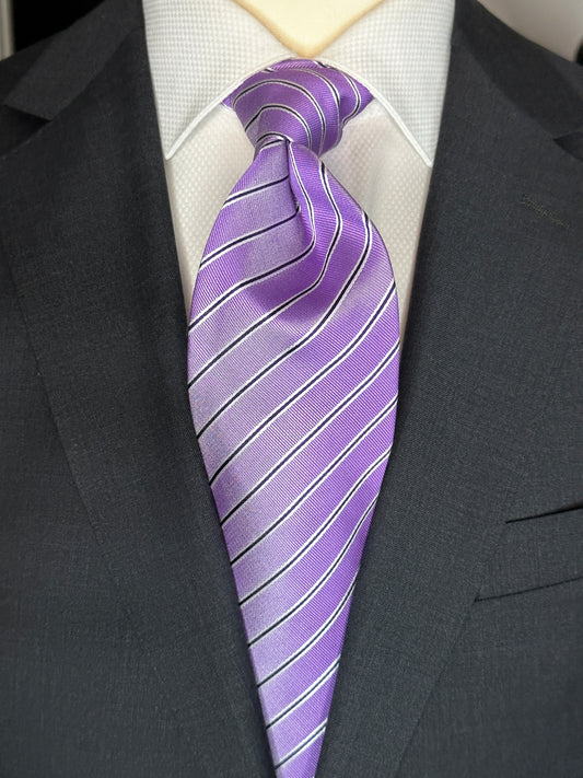 This lavender silk tie is extremely soft in color. The navy and narrow white pinstripes give it that extra definition. Woven silk creates a sturdy slightly thicker knot that stays all day. This color is great with a crisp white shirt, sky blue or pale lavender solid, stripes or plaid.  