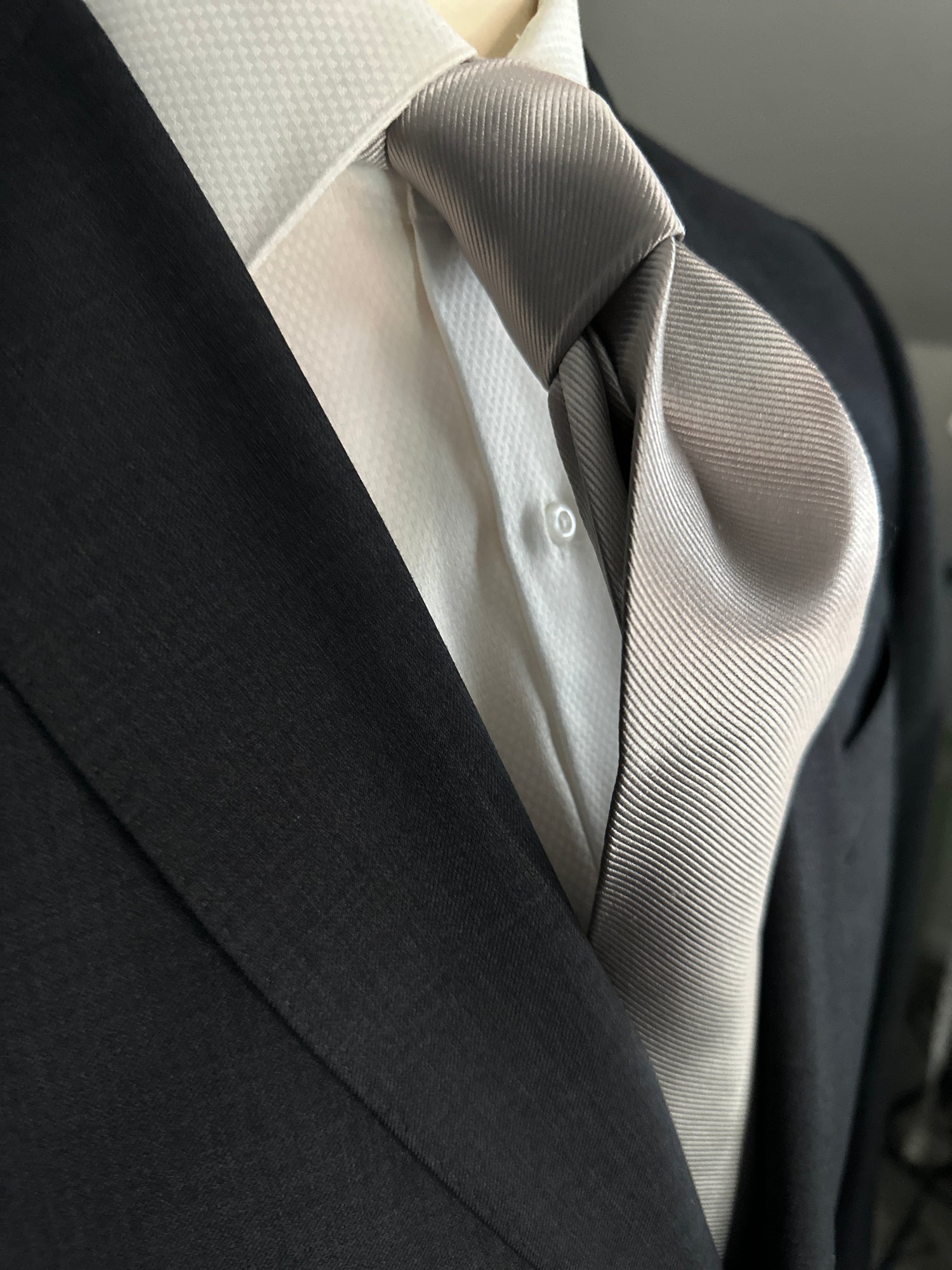 Solid ties are beautifully paired with the more busy of patters of bold stripes and heavy plaids. However, there is something so understated and elegant about a solid tie with a solid suit. Whether that be navy, charcoal or black a silver tie fits well with a white shirt and even a navy blazer with jeans. Silver necktie can also be used with formal wear. 