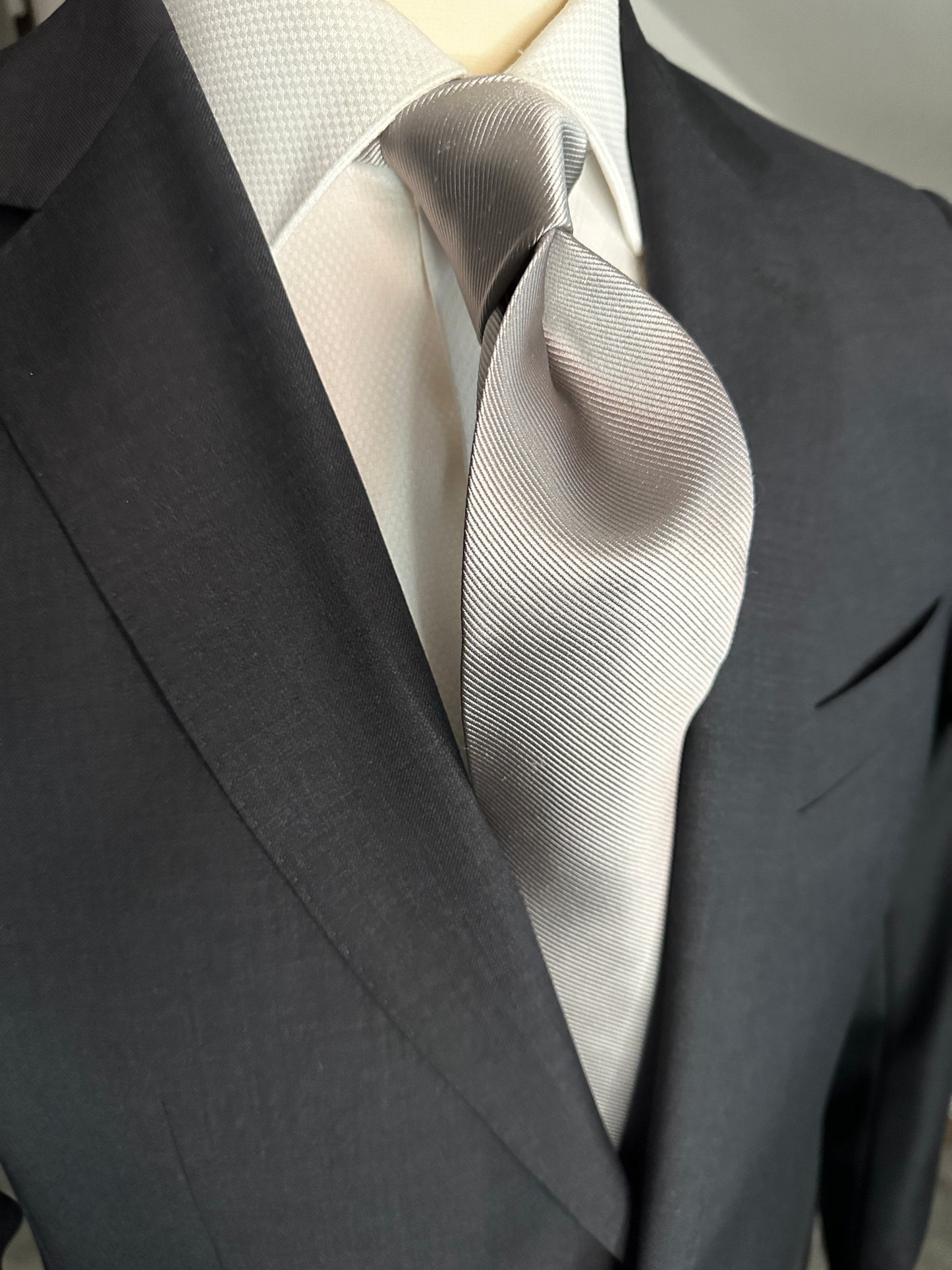 Solid ties are beautifully paired with the more busy of patters of bold stripes and heavy plaids. However, there is something so understated and elegant about a solid tie with a solid suit. Whether that be navy, charcoal or black a silver tie fits well with a white shirt and even a navy blazer with jeans. Silver necktie can also be used with formal wear. 