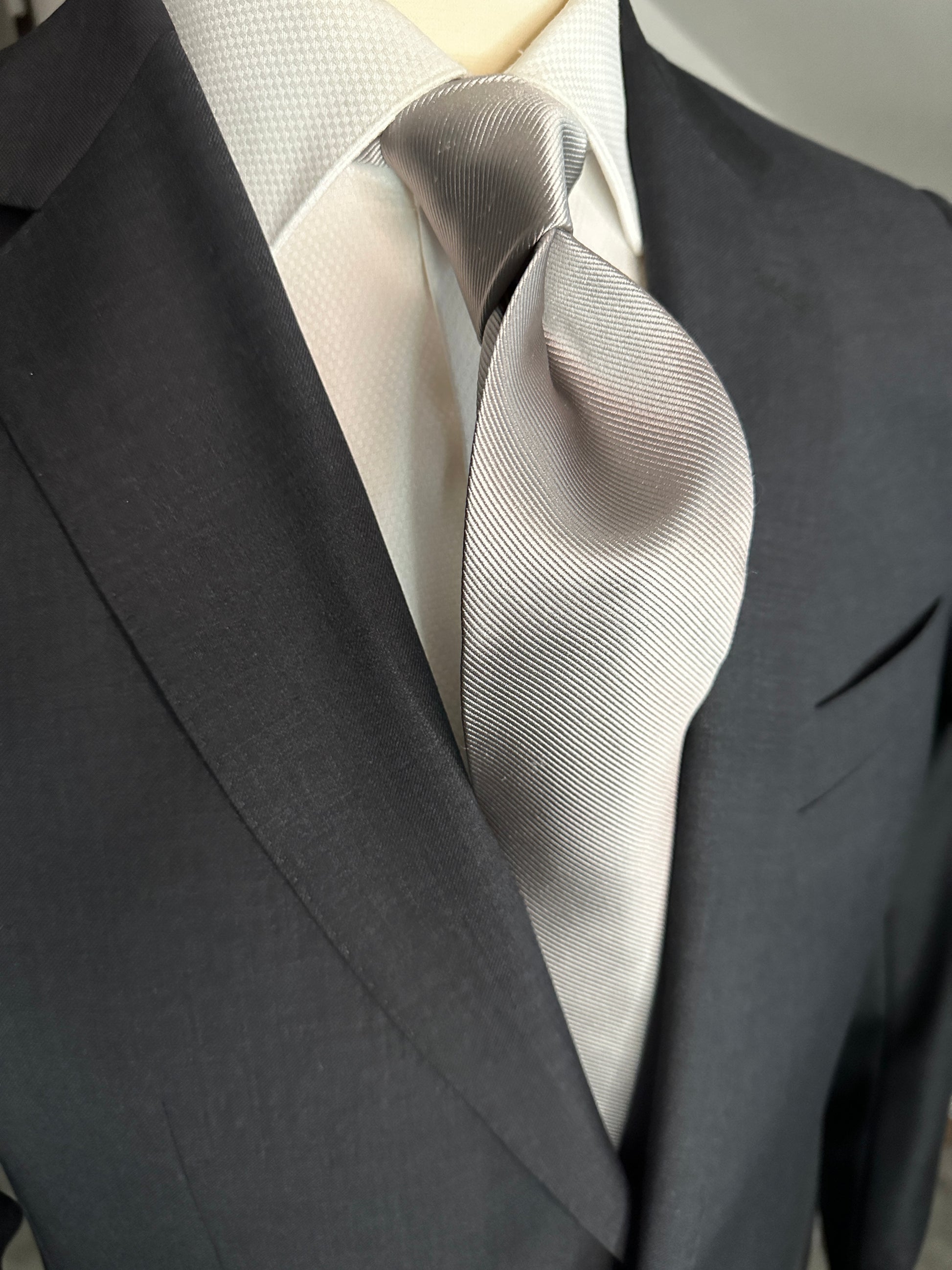 Solid ties are beautifully paired with the more busy of patters of bold stripes and heavy plaids. However, there is something so understated and elegant about a solid tie with a solid suit. Whether that be navy, charcoal or black a silver tie fits well with a white shirt and even a navy blazer with jeans. Silver necktie can also be used with formal wear. 