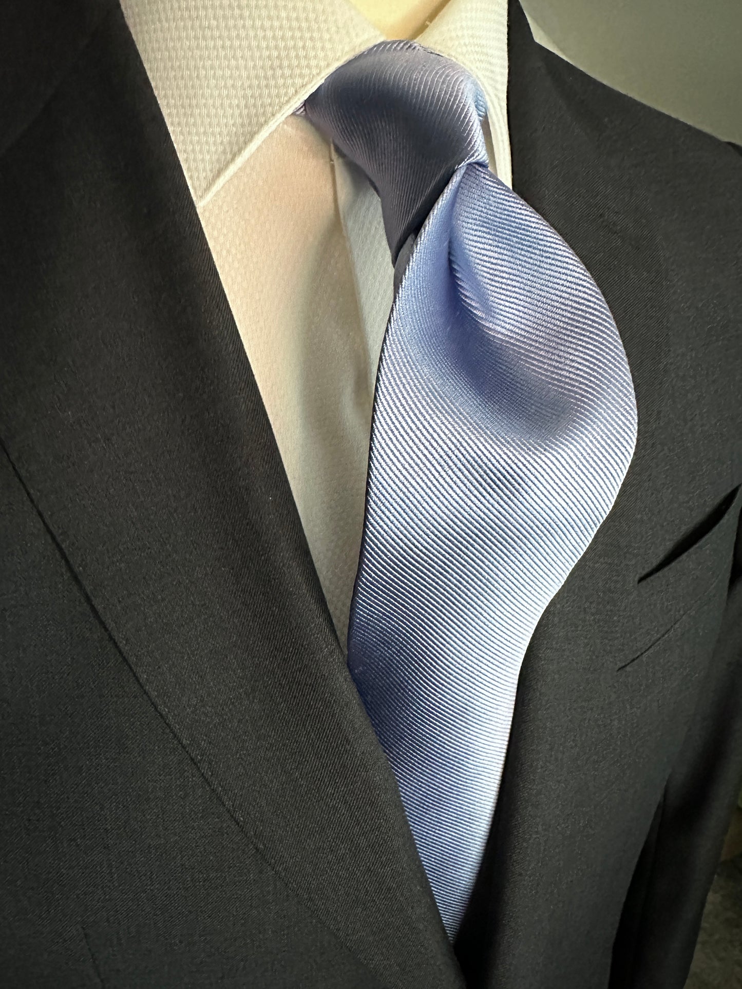 Solid ties are beautifully paired with the more busy of patters of bold stripes and heavy plaids. However, there is something so understated and elegant about a solid tie with a solid suit. Whether that be navy, charcoal or black a sky blue tie fits well with a white shirt and even a navy blazer with jeans.