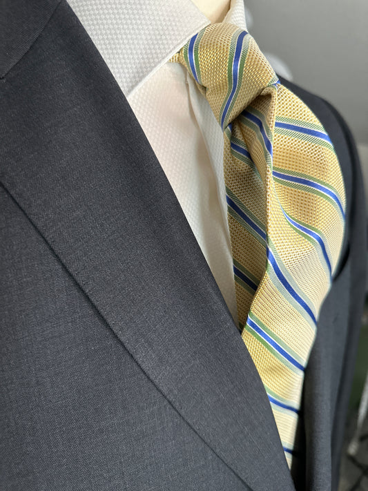 A general all around great tie to wear with any suit, shirt for any occasion. With two different types of silk in the same necktie, the stripe being satin and the broad section being woven, this tie makes an all day knot that does not have to be readjusted. With colorations of kelly green and blue stripes, you cannot make a mistake creating a look with this tie pairing with any suit in your closet.
