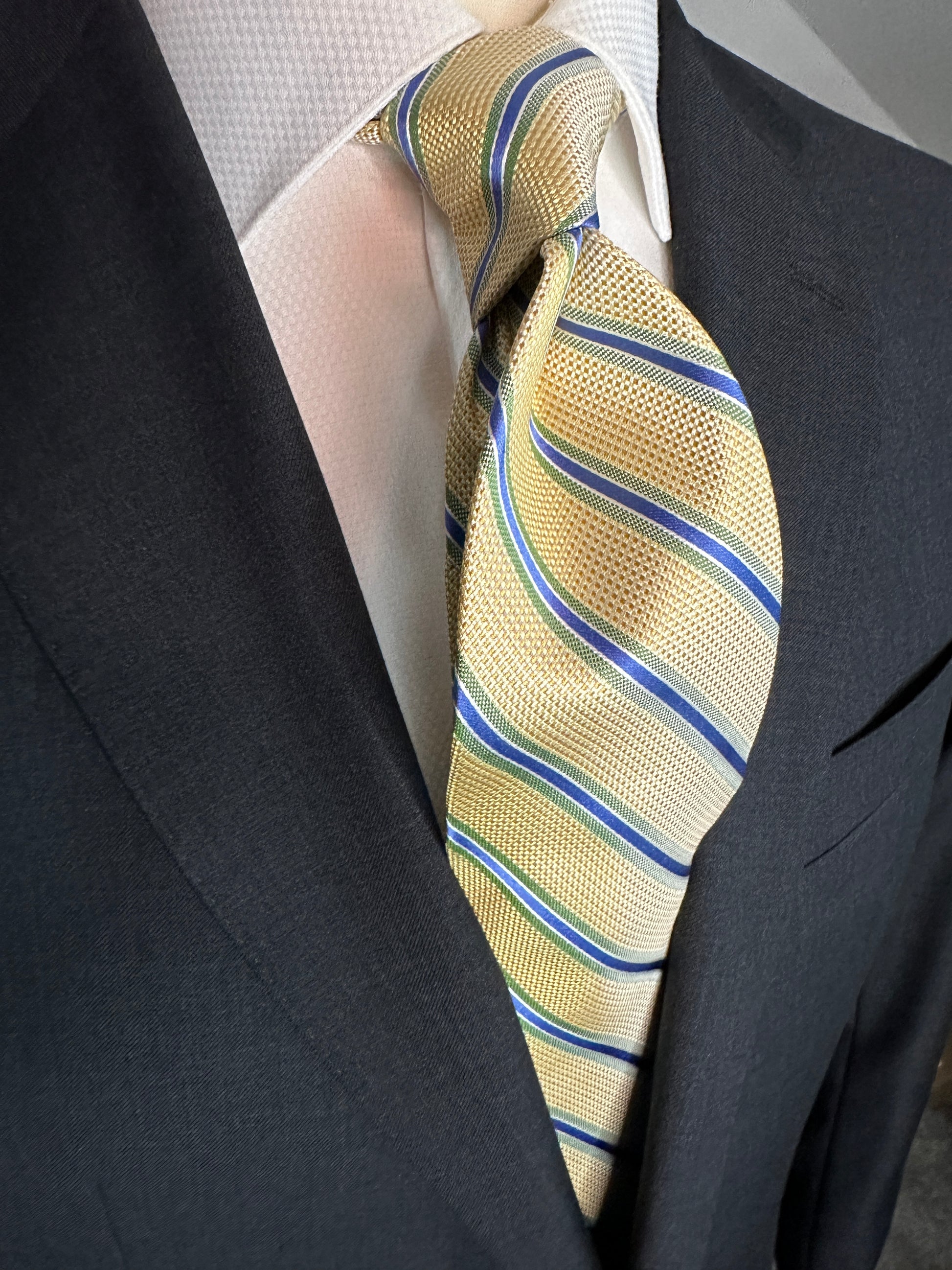 A general all around great tie to wear with any suit, shirt for any occasion. With two different types of silk in the same necktie, the stripe being satin and the broad section being woven, this tie makes an all day knot that does not have to be readjusted. With colorations of kelly green and blue stripes, you cannot make a mistake creating a look with this tie pairing with any suit in your closet.