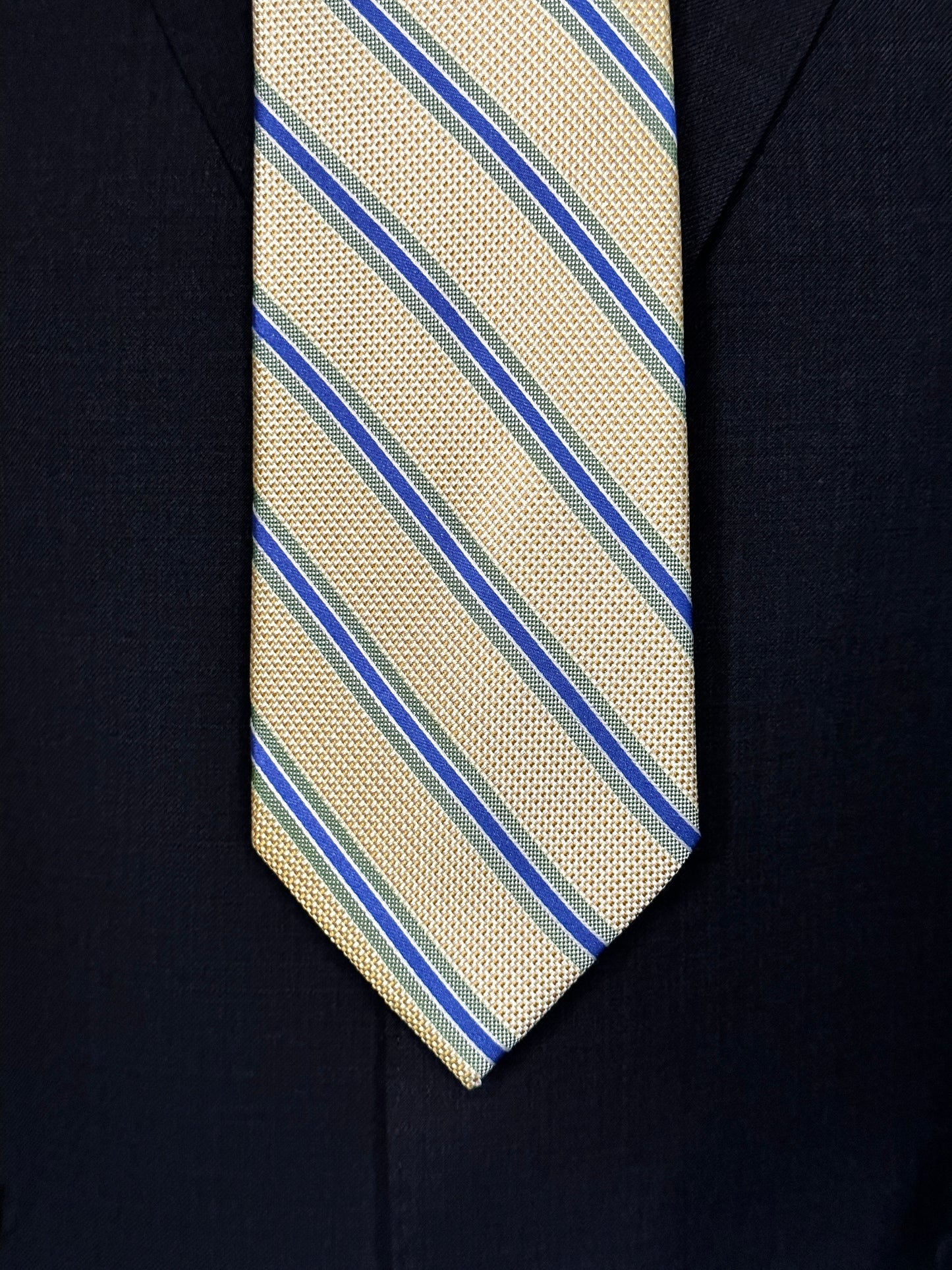 A general all around great tie to wear with any suit, shirt for any occasion. With two different types of silk in the same necktie, the stripe being satin and the broad section being woven, this tie makes an all day knot that does not have to be readjusted. With colorations of kelly green and blue stripes, you cannot make a mistake creating a look with this tie pairing with any suit in your closet.
