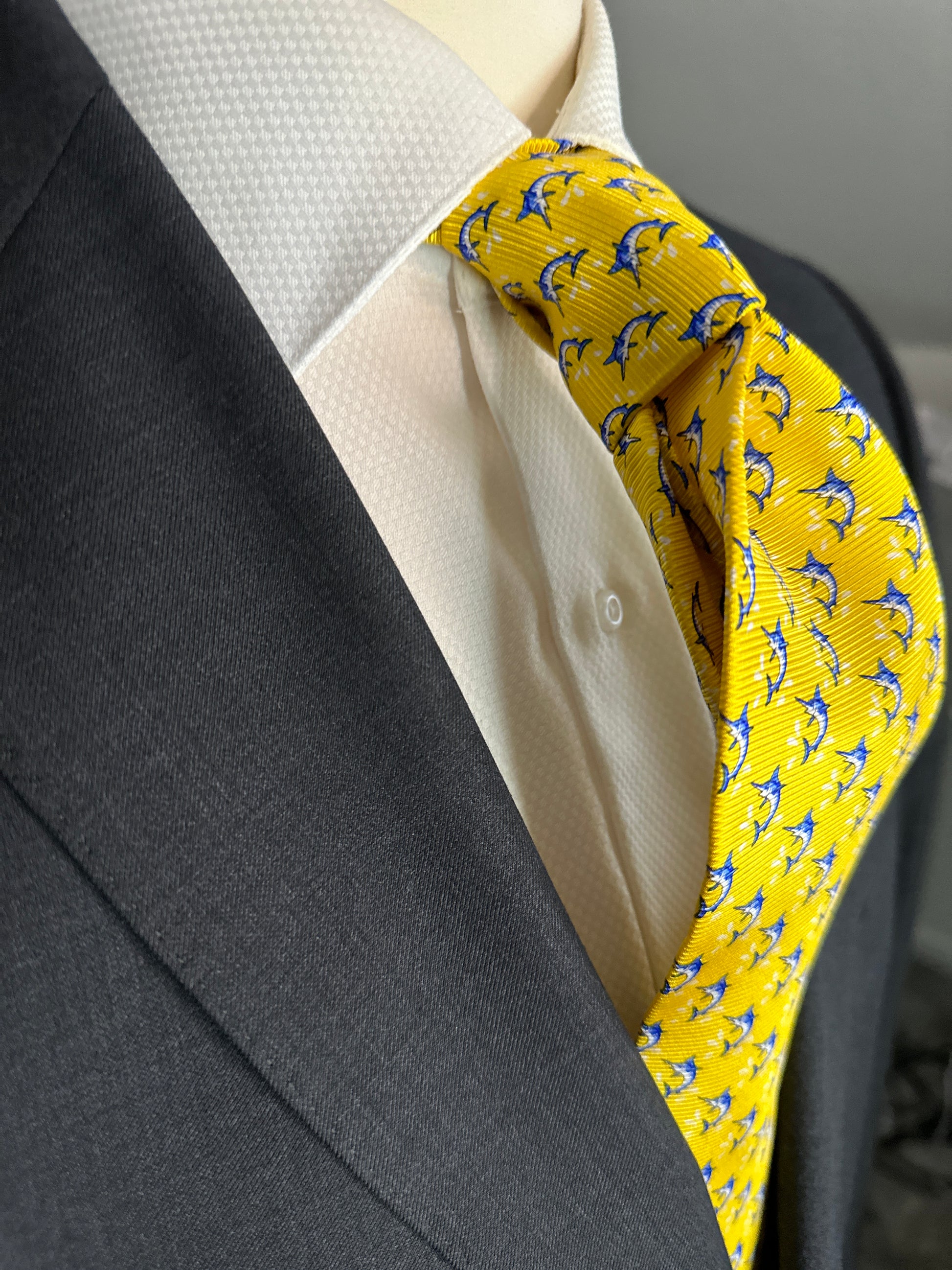 This beautiful 100% silk twill necktie features the swordfish motif with small splashes of water. Being a geometric type pattern, this tie is most interesting because people tend to look twice to realize that the pattern is made up of blue swordfish. Hermes style..