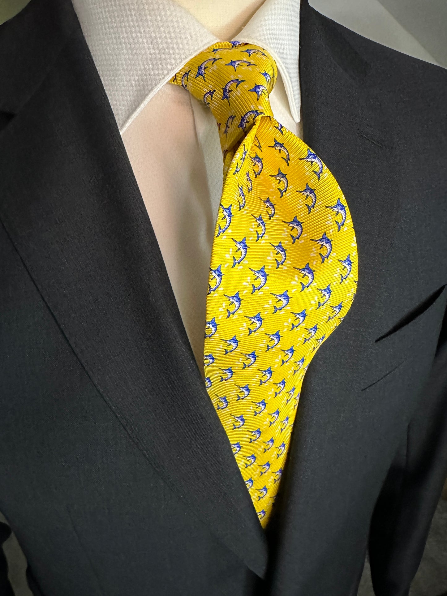 This beautiful 100% silk twill necktie features the swordfish motif with small splashes of water. Being a geometric type pattern, this tie is most interesting because people tend to look twice to realize that the pattern is made up of blue swordfish. Hermes style..